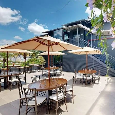 Terraço do Espaço Vista, com mesas, ombrelones e vista para a cidade